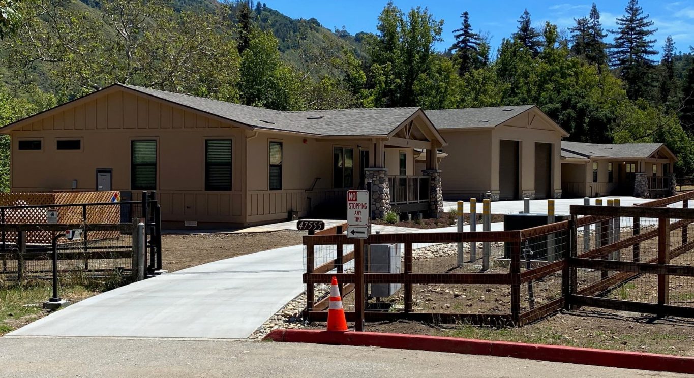 CHP government housing in Big Sur, CA. Modular construction with garage, carports, and paved driveway. Nestled in the forest.