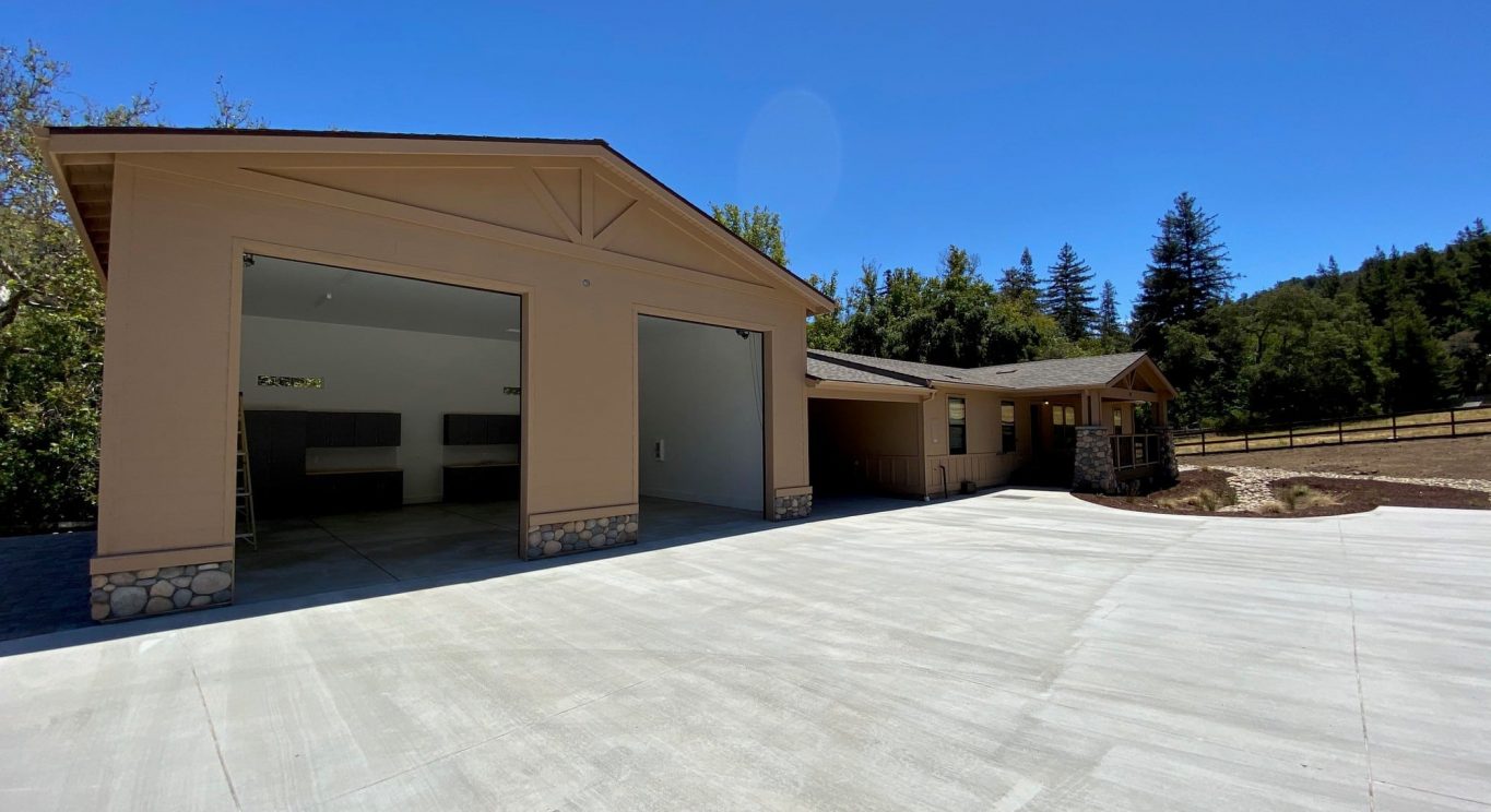 CHP government housing in Big Sur, CA. Modular construction with garage, carports, and paved driveway. Nestled in the forest.