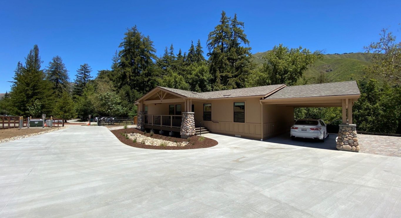 CHP government housing in Big Sur, CA. Modular construction with garage, carports, and paved driveway. Nestled in the forest.