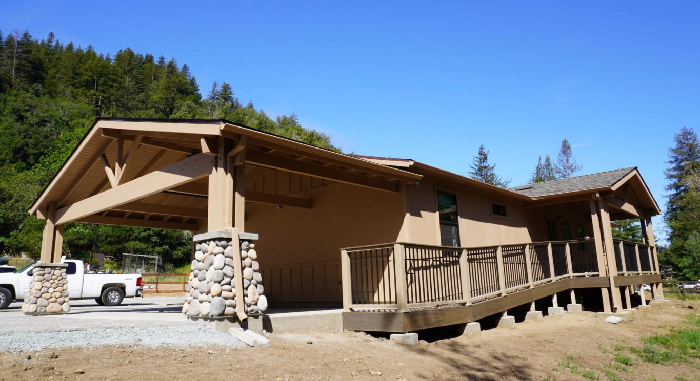 CHP government housing in Big Sur, CA. Modular construction with garage, carports, and paved driveway. Nestled in the forest.