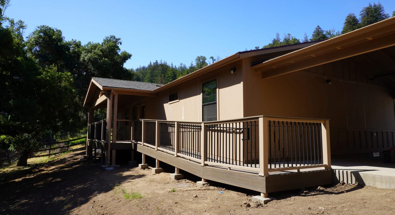 CHP government housing in Big Sur, CA. Modular construction with garage, carports, and paved driveway. Nestled in the forest.