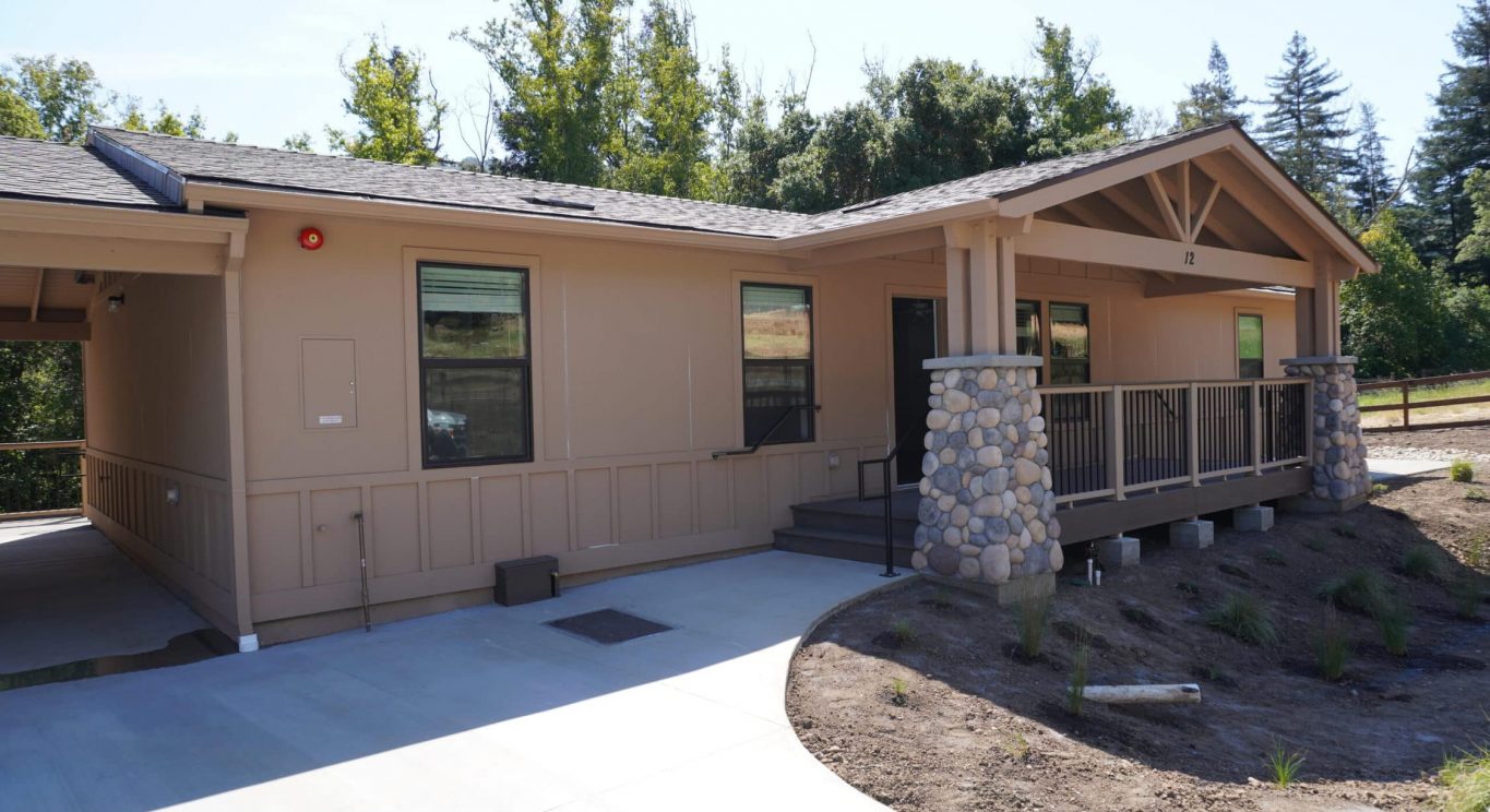 CHP government housing in Big Sur, CA. Modular construction with garage, carports, and paved driveway. Nestled in the forest.