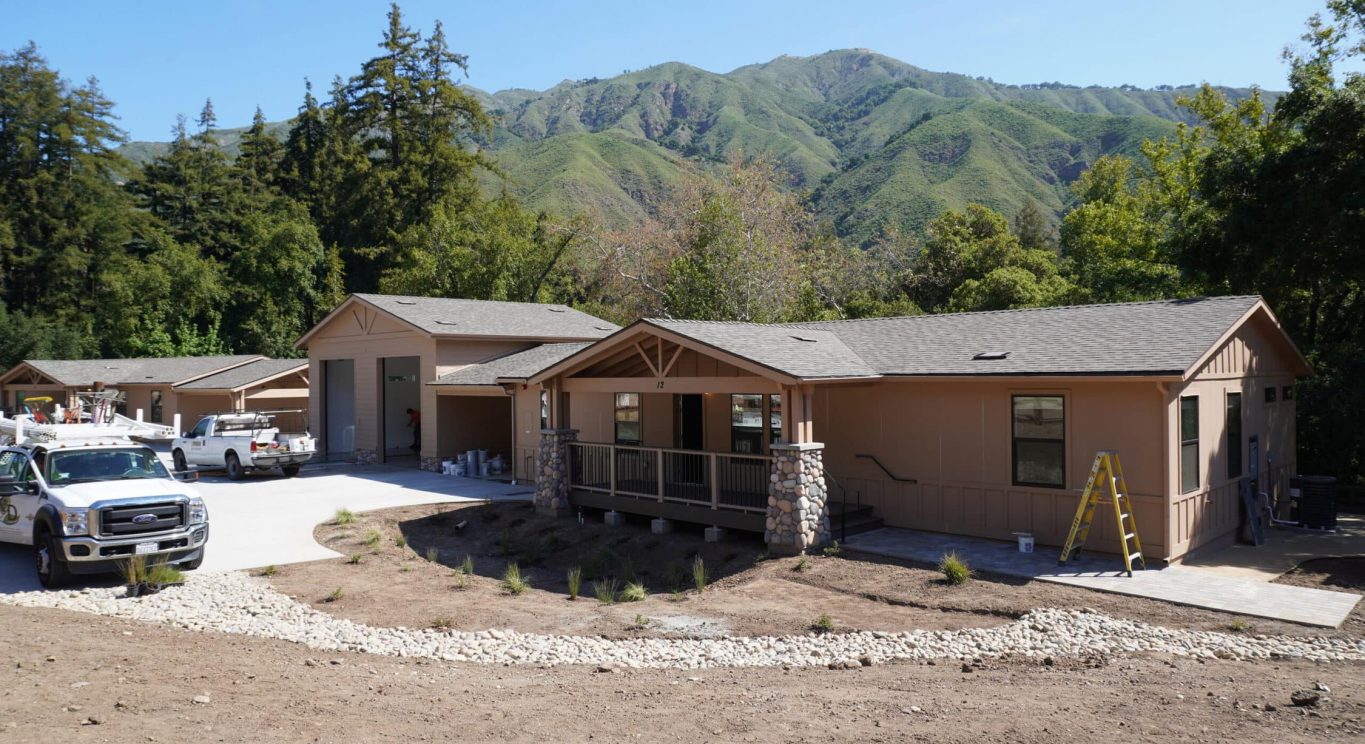 CHP government housing in Big Sur, CA. Modular construction with garage, carports, and paved driveway. Nestled in the forest.