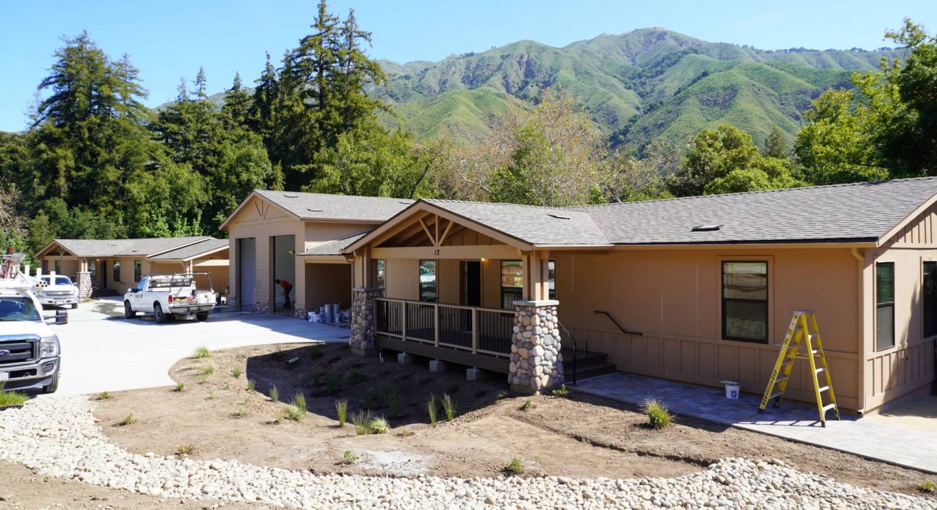 CHP government housing in Big Sur, CA. Modular construction with garage, carports, and paved driveway. Nestled in the forest.