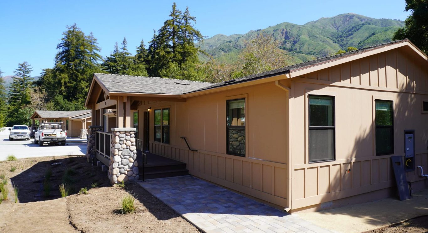 CHP government housing in Big Sur, CA. Modular construction with garage, carports, and paved driveway. Nestled in the forest.