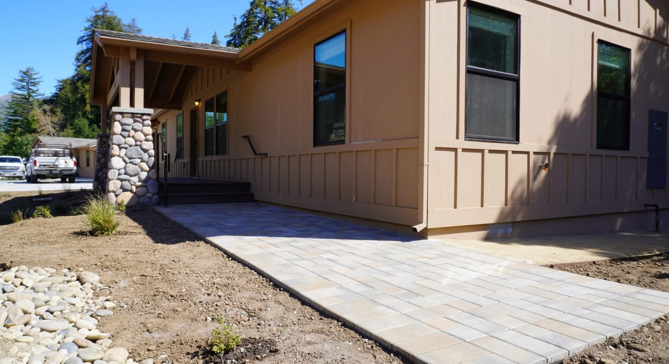 CHP government housing in Big Sur, CA. Modular construction with garage, carports, and paved driveway. Nestled in the forest.