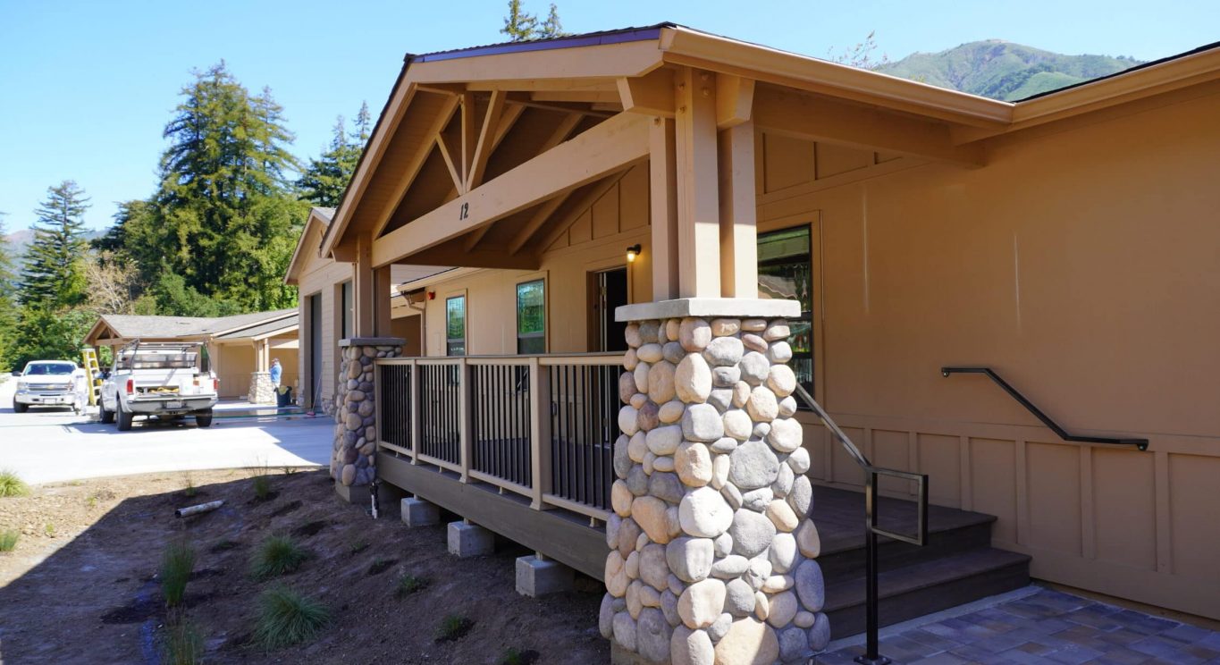 CHP government housing in Big Sur, CA. Modular construction with garage, carports, and paved driveway. Nestled in the forest.