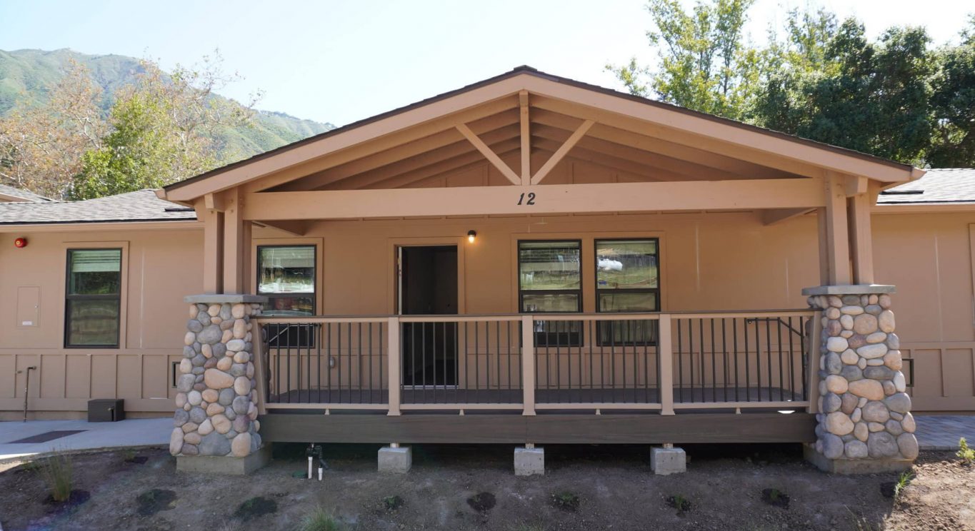 CHP government housing in Big Sur, CA. Modular construction with garage, carports, and paved driveway. Nestled in the forest.