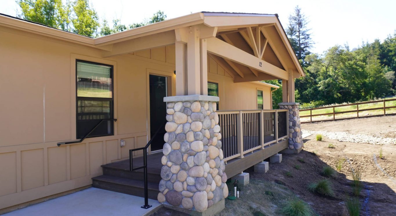 CHP government housing in Big Sur, CA. Modular construction with garage, carports, and paved driveway. Nestled in the forest.