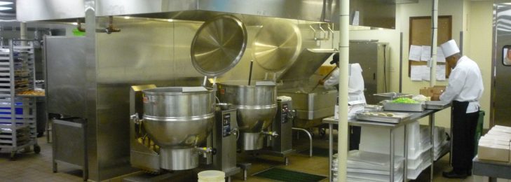 Kitchen area inside a restaurant, with chefs preparing food.